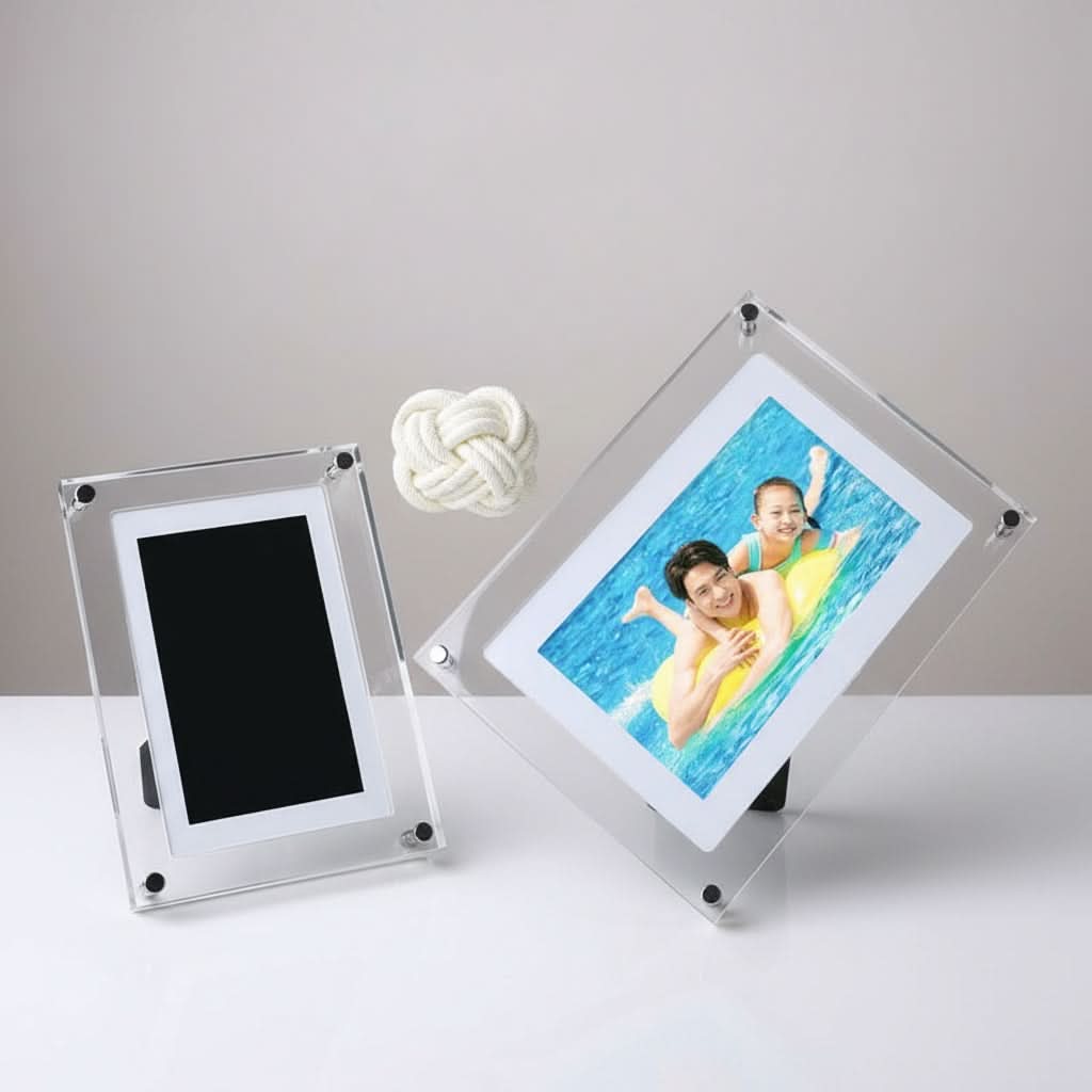 Two clear acrylic photo frames on a white surface with a gray background