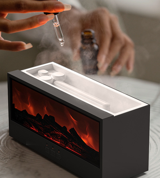 Hand holding a dropper over a small device with flames inside, on a neutral background