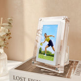 Clear photo frame displaying a woman playing tennis on a table with a beige background