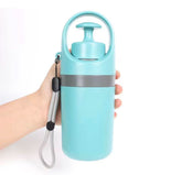 Light blue water bottle with a handle held by a hand on a white background
