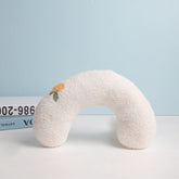 White neck pillow with floral design on a light blue background