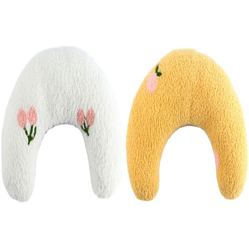Two soft, crescent-shaped toys in white and yellow with floral designs on a white background.