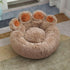 Fluffy paw-shaped pet bed in beige with orange accents, cozy for cats or dogs, on a rug