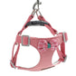Pink adjustable dog harness with plaid bowtie detail and metal clip attachment.