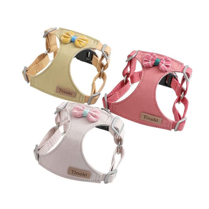 Three cute small dog harnesses in pastel yellow, pink, and beige with bow tie accents
