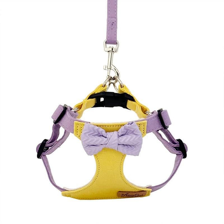 Yellow and lavender dog harness and leash set with a decorative bow on white background