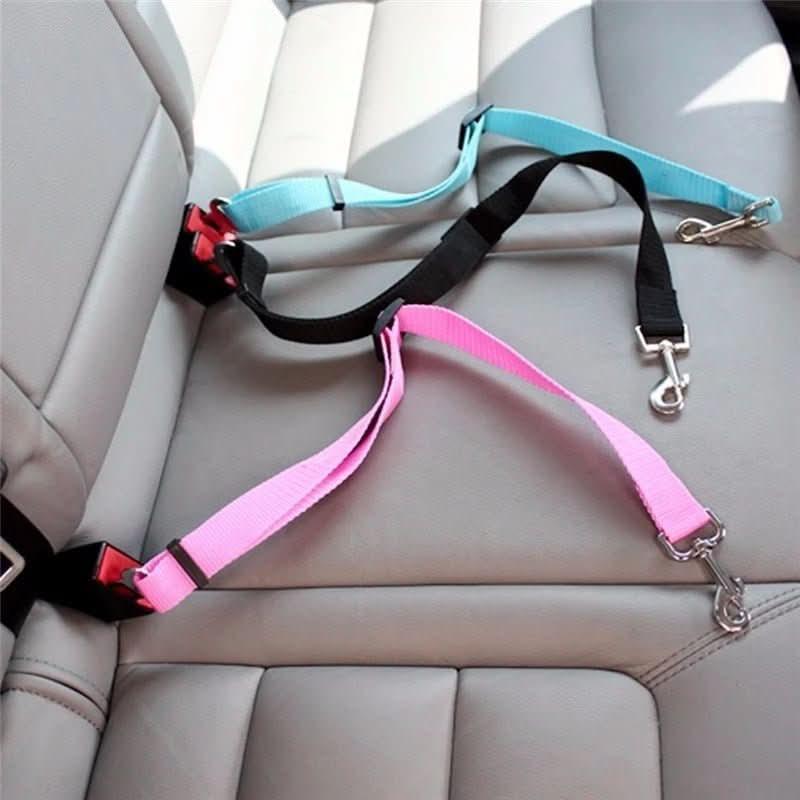 Pink and blue adjustable dog car seat belts attached to a car&