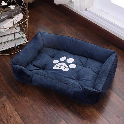 Navy blue plush pet bed with raised sides and paw print for dogs or cats on wooden floor