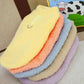 Stack of plush velvet winter dog coats in soft pastel colors with ring detail