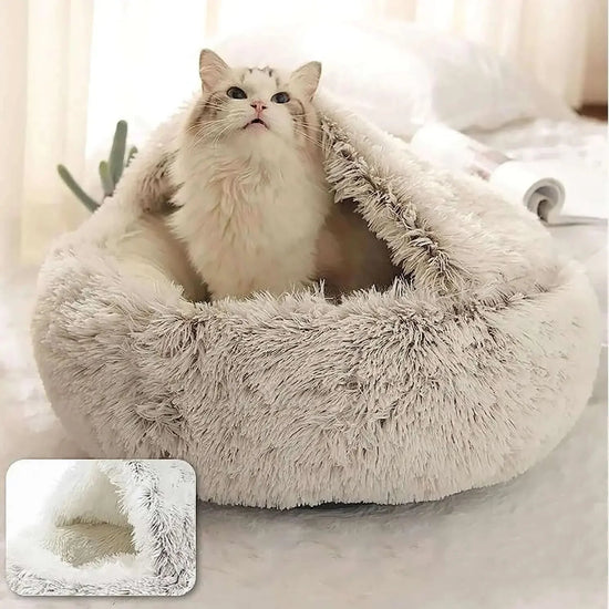 Fluffy cat in a semi-enclosed plush pet bed on a cozy indoor surface